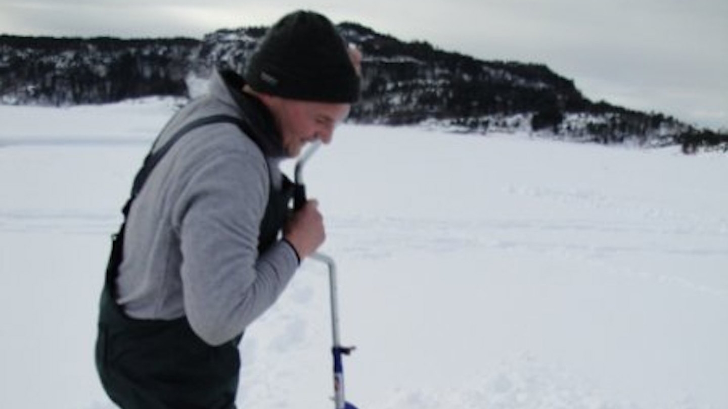 Isfiskare gör hål i isen. Foto: Anneriek Barree