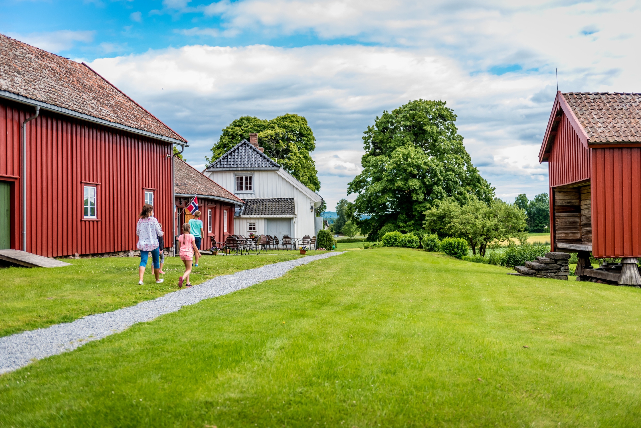 Människor på en bondgård med röda hus